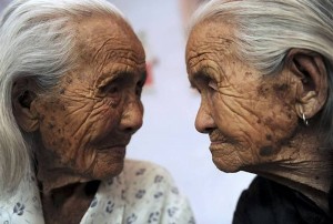 Chinese 104-year-old twins Cao Xiaoqiao and her elder sister Daqiao look at each other in Zhucheng